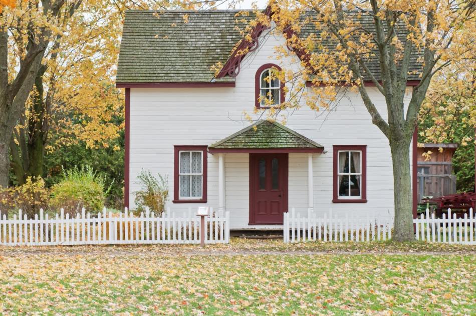 A picture of a home with a small white picket fence in the yard