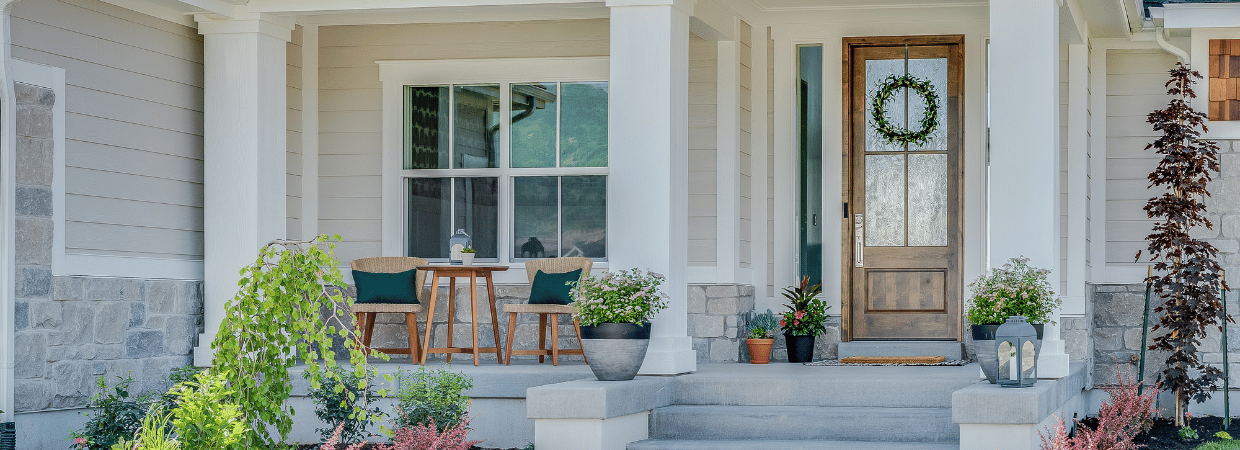 A picture of a front porch with furniture and plants